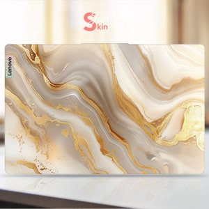 Op de afbeelding: Een witte en gouden marmeren laptop skin met het woord "Lenovo" gedrukt op de linkerzijde.
