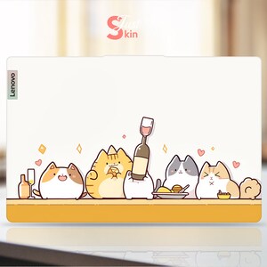 May include: A white laptop skin featuring a design of five cartoon cats enjoying a dinner party. The cats are orange, white, grey, and orange and white. They are depicted eating food and drinking wine. The skin has the word "Lenovo" on the left side.