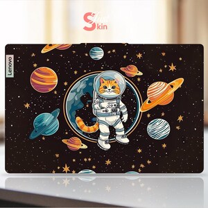 May include: A Lenovo laptop skin with a cartoon cat astronaut in a spacesuit, set against a backdrop of planets and stars on a dark background. The skin has the text "Skin Kin" and the Lenovo logo.