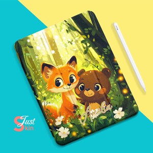 May include: A green, yellow, and brown iPad case with a cartoon fox and bear in a forest setting. The case has the name "Amelia" written on it.