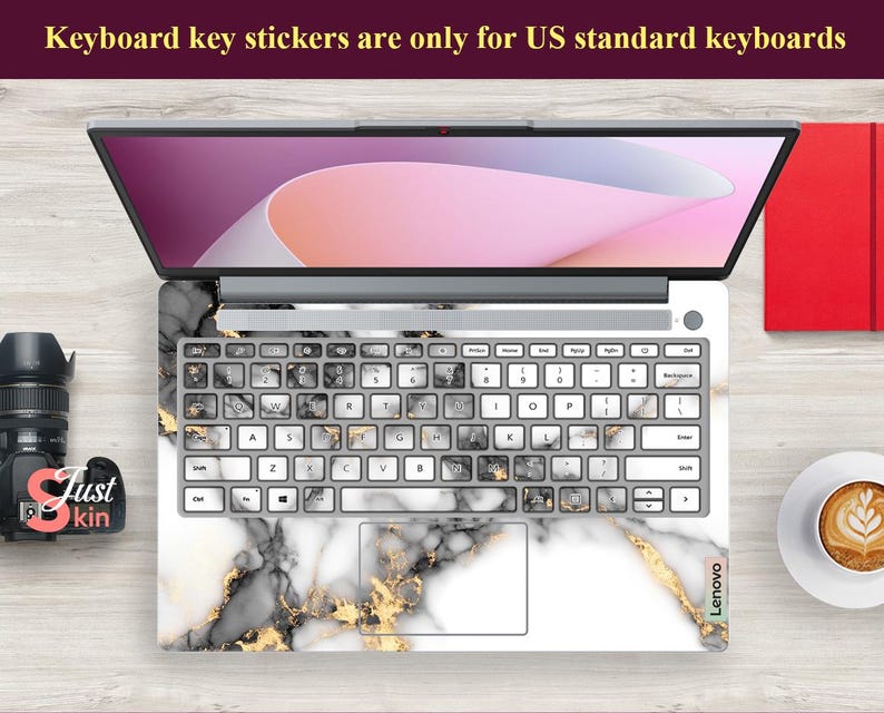 May include: A white laptop with a black and gold marble design keyboard sticker. The sticker has the text "Lenovo" on the bottom right corner. The text "Keyboard key stickers are only for US standard keyboards" is at the top of the image.