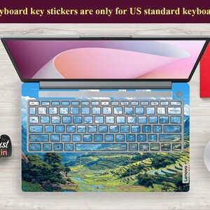 May include: Laptop keyboard skin with a landscape design featuring green terraced fields, blue sky, and white clouds. The keyboard keys are light blue. The text on the top says: "Keyboard key stickers are only for US standard keyboards."