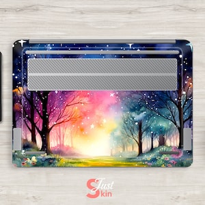 May include: A laptop skin with a watercolor design of a forest path with trees on either side. The path leads to a bright light at the end. The background is a dark blue sky with stars and a pink and orange sunset.