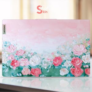 Peut inclure: Une peau d'ordinateur portable &agrave; fleurs roses et vertes avec le mot "Lenovo" en blanc sur le c&ocirc;t&eacute; gauche.