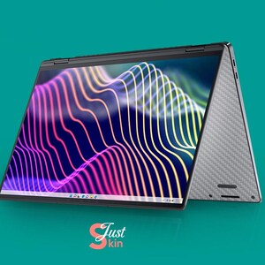 May include: A silver laptop computer with a black screen displaying a colorful abstract design. The laptop is open and the lid is folded back, revealing the keyboard and trackpad. The laptop is sitting on a teal surface.