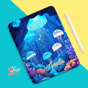 May include: A blue and purple iPad case featuring a design of jellyfish and coral. The case is personalised with the name "Amelia" in gold lettering.