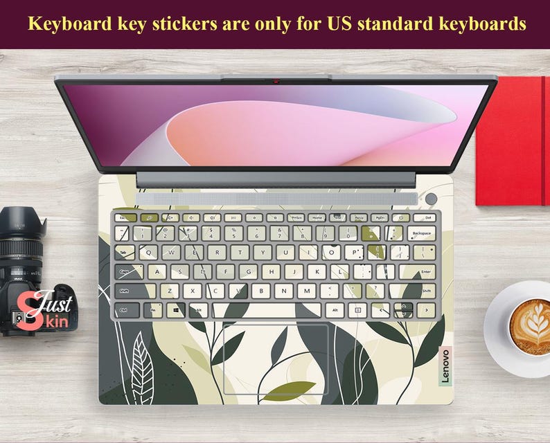 May include: A laptop computer with a white and green floral keyboard sticker. The sticker features a leafy pattern with abstract shapes. The text "Keyboard key stickers are only for US standard keyboards" is displayed at the top of the image.