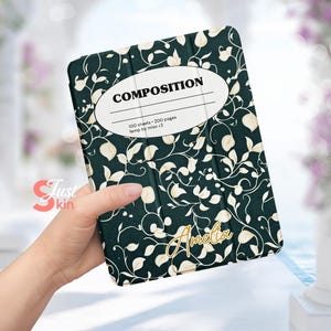 Puede incluir: Una funda para iPad de color verde y blanco con estampado floral y la palabra "COMPOSITION" en un óvalo blanco en la parte delantera. La funda también tiene el texto "100 hojas - 200 páginas temp by miso <3" y el nombre "Amelia" en letras doradas.