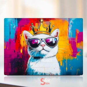 Puede incluir: Un gato blanco con una corona dorada y gafas de sol sobre un fondo de graffiti colorido. El gato tiene una expresión seria y mira directamente al espectador.