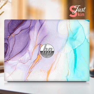 May include: A laptop skin with a purple, blue, and white abstract marble design. The skin has a gold glitter effect and the HP logo is visible in the center.