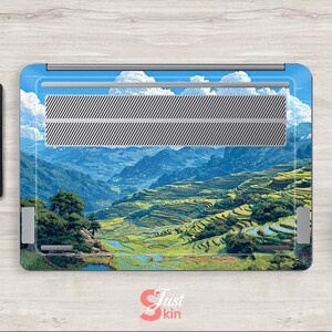 May include: Laptop skin featuring a scenic landscape of terraced rice fields and mountains under a blue sky with fluffy white clouds. The skin has a silver vent area and the text "Just Skin" in the bottom right corner.