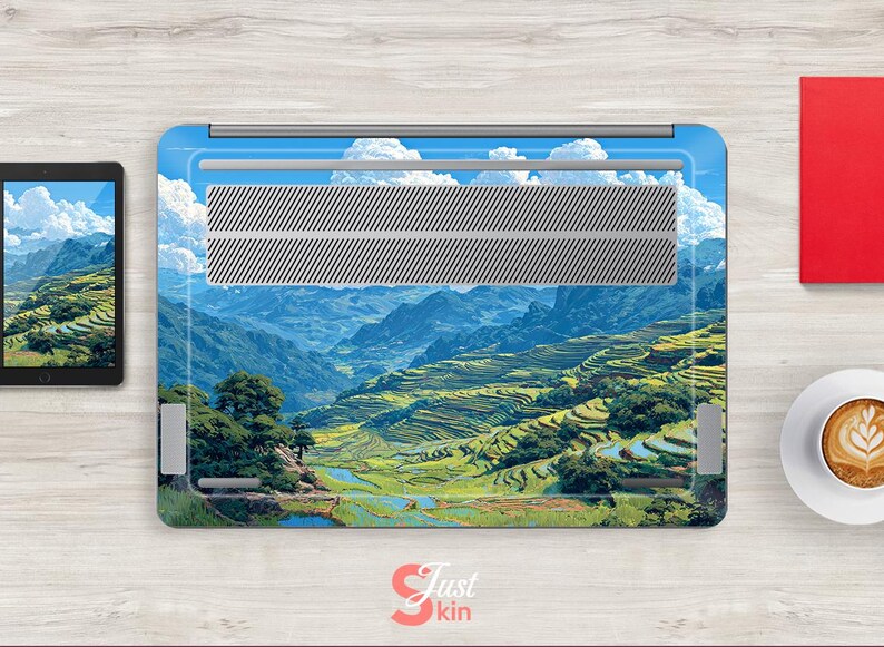May include: Laptop skin featuring a scenic landscape of terraced rice fields and mountains under a blue sky with fluffy white clouds. The skin has a silver vent area and the text "Just Skin" in the bottom right corner.