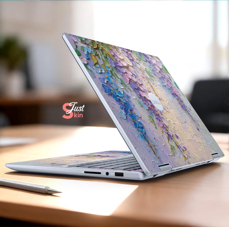 K&ouml;nnte beinhalten: Ein Laptop mit floralem Design. Die H&uuml;lle des Laptops zeigt ein strukturiertes Gem&auml;lde aus lila, blauen und gelben Blumen. Der Text "Just kin" ist auf der Seite des Laptops zu sehen.