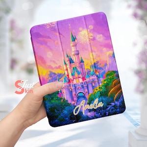 May include: Purple and pink tablet case featuring a colourful illustration of a castle and fireworks. The name Amelia is written in gold lettering on the case.