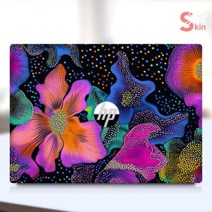 May include: A laptop skin with a colorful abstract design featuring a black background with pink, blue, green, and yellow floral patterns. The design is reminiscent of a galaxy with stars and nebulae.