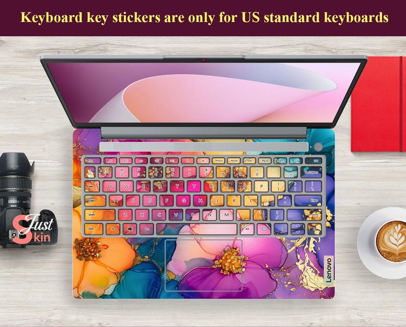 May include: Laptop with a colorful floral design keyboard skin and key stickers. The keyboard skin features a vibrant mix of orange, purple, and blue hues with gold accents. The text on the image says "Keyboard key stickers are only for US standard keyboards."