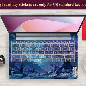 K&ouml;nnte beinhalten: Ein Lenovo-Laptop mit einer benutzerdefinierten Tastaturhaut mit einem blau-violetten Landschaftsdesign. Die Tastaturtasten sind mit Aufklebern bedeckt. Der Text oben lautet "Keyboard key stickers are only for US standard keyboards."