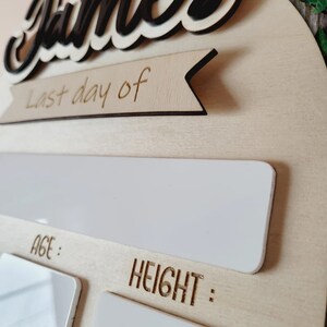 May include: A wooden growth chart with the name "James" in black lettering. The chart has a banner that says "Last day of" and includes spaces to record age and height.