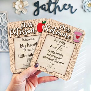 May include: Two wooden teacher appreciation plaques. One says "Mrs. Peterson" and "It takes a big heart to teach little minds." The other says "Mrs. Katarine" and "Just a little note to say thanks for being an awesome teacher!"