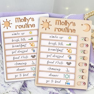 May include: A wooden checklist with a sun and moon design. The checklist is labeled "Molly's routine" and includes tasks like "wake up", "brush teeth", "breakfast", "get dressed", "feed Milo", "cleaning", "dinner", and "go to bed". Each task has a corresponding icon and a toggle switch to mark it as complete.