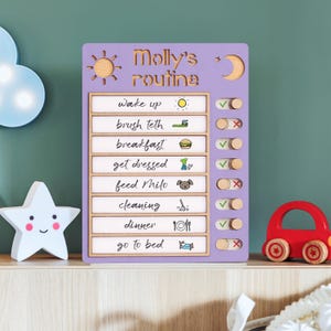 May include: A wooden, lavender-colored daily routine chart with the text "Molly's routine." The chart includes sections for tasks like "wake up" and "go to bed," with check boxes. A wooden sun and moon are at the top.