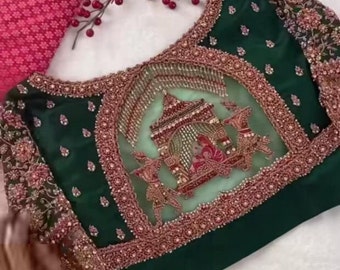 May include: A green and red embroidered blouse back with a sheer panel featuring a decorative design.