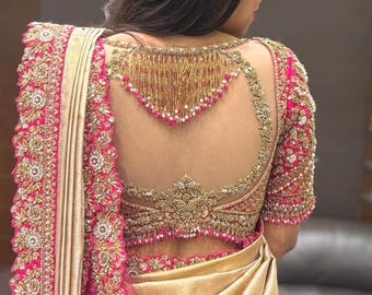 May include: A pink and gold embroidered blouse with a sheer back and a beaded neckline.