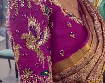 May include: A magenta blouse with intricate embroidery featuring a bird design, sequins, and beads. The blouse has a scoop neckline and three-quarter sleeves.
