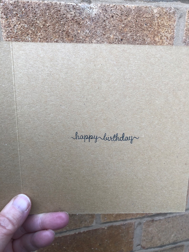 May include: A brown card with the text "happy birthday" written in black cursive.