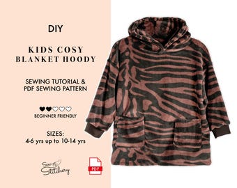 Puede incluir: Una sudadera tipo manta con estampado de rayas de tigre en marrón y negro, con capucha, mangas largas y dos bolsillos delanteros. El texto dice: DIY KIDS COSY BLANKET HOODY SEWING TUTORIAL & PDF SEWING PATTERN BEGINNER FRIENDLY SIZES: 4-6 yrs up to 10-14 yrs.