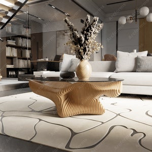 May include: A modern, abstract wooden coffee table with a glass top. The table has a unique, organic shape with a layered design. The table is sitting on a cream-colored rug with a gray pattern.