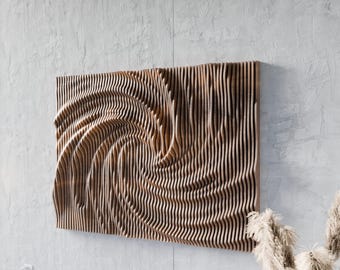 May include: Wooden wall art with a swirling, three-dimensional design. The artwork is made of vertical wooden slats that create a wave-like pattern. The wood has a natural, light brown color, and the piece is mounted on a light gray wall.