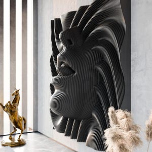 May include: A large, black, three-dimensional wall sculpture featuring a layered, topographic design that forms the abstract shape of a human face in profile, with deep, rhythmic grooves creating a sense of movement and texture across the surface.