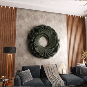 Puede incluir: Una sala de estar moderna con un sofá seccional gris oscuro, una pared de madera con listones verticales y una gran escultura de pared circular verde. El sofá tiene una manta de tiro gris y una lámpara blanca en la mesa auxiliar.