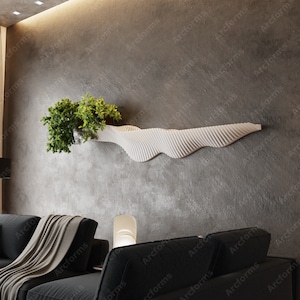 May include: A white, wavy, wall-mounted shelf with a potted plant on top. The shelf is made of a textured material and has a modern design. The shelf is mounted on a gray wall.