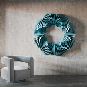 May include: A teal blue geometric wall sculpture in the shape of a circle with a starburst design. A gray swivel chair sits in front of the sculpture.