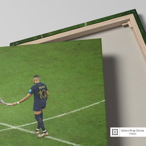 May include: A soccer player wearing a blue jersey with the number 10 and the name "MBAPPE" on the back. The player is standing on a green field with white lines.