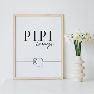 Könnte beinhalten: Ein gerahmter Druck mit dem Text "PIPI Lounge" und einer einfachen Strichzeichnung einer Toilettenpapierrolle. Der Druck ist in einem hellen Holzrahmen und liegt auf einer weißen Oberfläche. Rechts vom Druck steht eine Vase mit weißen Blumen.