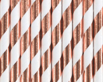 May include: A close-up of a set of white and rose gold striped paper straws. The straws are arranged in a row, with the rose gold stripes facing the viewer.