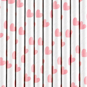 Op de afbeelding: Een set witte papieren rietjes met roze hartjes erop gedrukt. De rietjes zijn perfect om een vleugje speelsheid toe te voegen aan elk feestje of evenement.