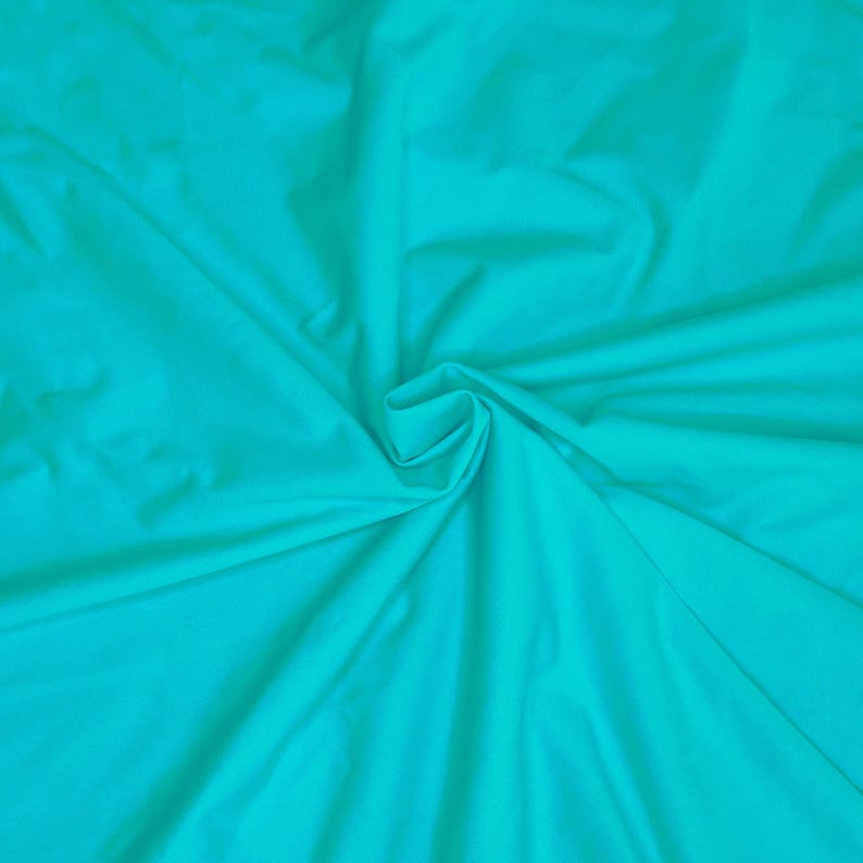 May include: A close-up of a turquoise fabric with soft folds and wrinkles.