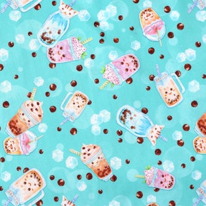 May include: A turquoise blue fabric with a repeating pattern of various bubble tea drinks. The drinks are in different colors and shapes, including jars, cups, and bottles. Some of the drinks have cute faces and straws. The background is a light turquoise blue with brown boba pearls and white ice cubes.