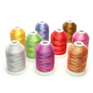 May include: Assortment of eight spools of iridescent embroidery thread in various colours, including pink, blue, green, yellow, and orange. The spools are arranged in a semi-circle on a white background.