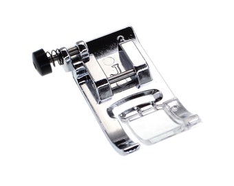 May include: A silver sewing machine foot with a clear plastic guide and a spring-loaded adjustment knob. The foot is labeled with the letter "J".