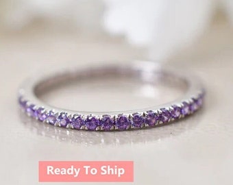 May include: A delicate silver band ring with a row of small purple gemstones.