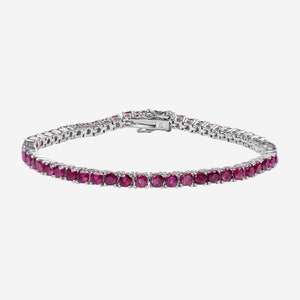 Könnte beinhalten: Ein silbernes Tennisarmband mit einer Reihe runder, roter Rubin-Steine.