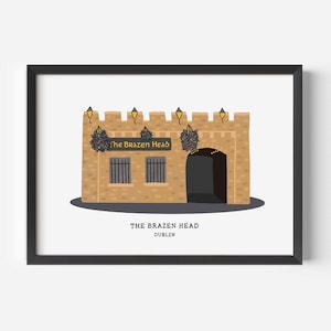 Op de afbeelding: Ingelijste print met een gestileerde illustratie van The Brazen Head pub in Dublin. Het kunstwerk toont een bruin bakstenen gebouw met een zwarte boogvormige deuropening, twee ramen en decoratieve hangplanten. De tekst "The Brazen Head Dublin" is eronder gedrukt.