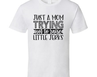 Camiseta divertida y sarcástica con texto en inglés "Just A Mom Trying To Not Raise Little Jerks"