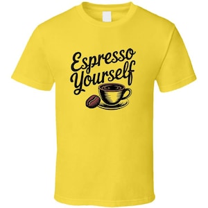 以下が含まれることがあります： 黒い文字で「Espresso Yourself」と書かれた黄色のTシャツ。テキストの下には、コーヒーカップとコーヒー豆の漫画の画像があります。