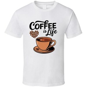 May include: White t-shirt with a black graphic that says "Coffee is Life" with a brown coffee cup and coffee beans in the shape of a heart.